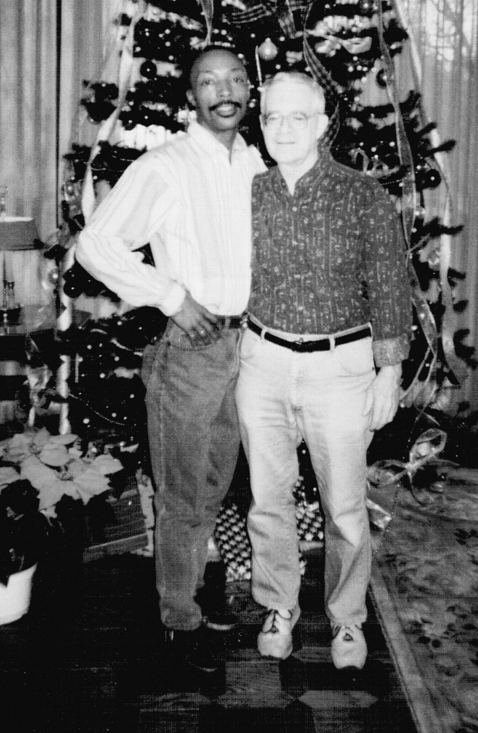 Archie and Jack standing together in front of a Christmas tree